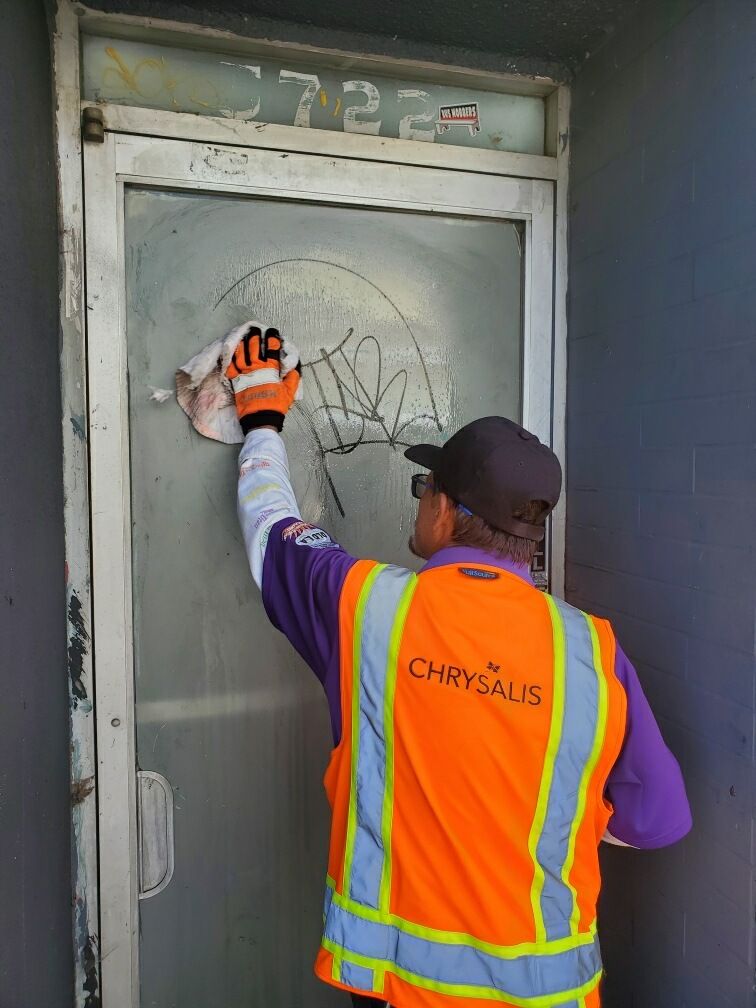 Crew member removing graffiti from a door